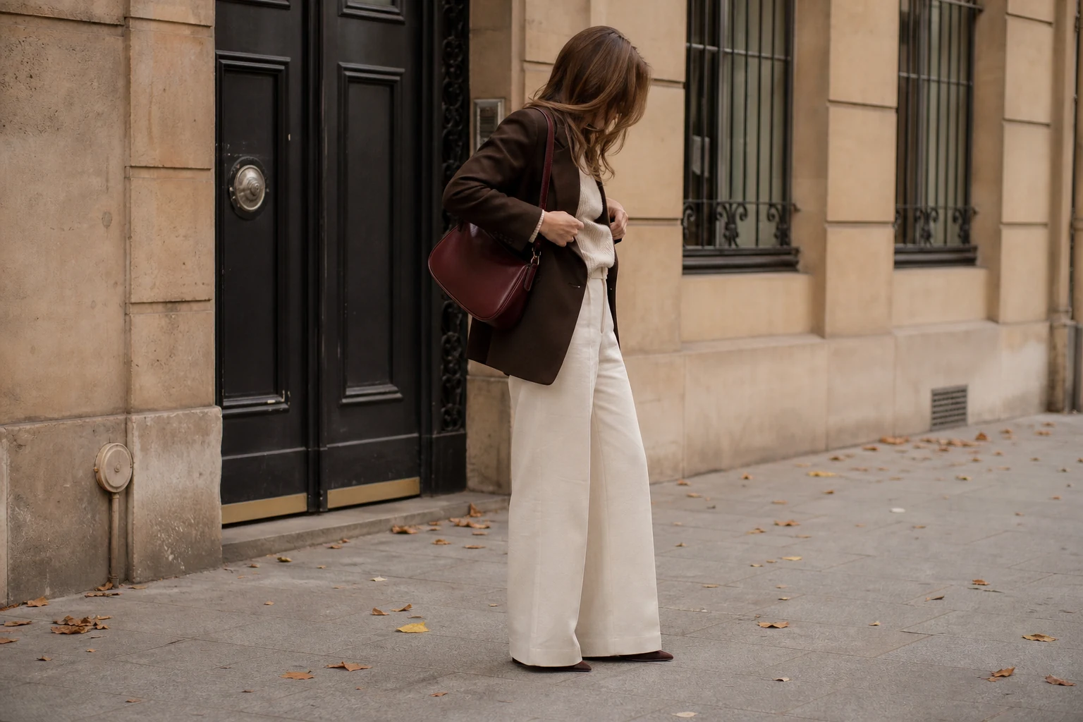 A cream and chocolate outfit with a burgundy shoulder bag as the single accent